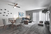 Located at 5200 S J St in Oxnard, California, this two-story residence offers a thoughtfully designed layout spread across two floors, as seen in the dollhouse view showcasing a staircase connecting the living spaces to the upper-level bedrooms.

The living room is a welcoming, light-filled space featuring wood-look flooring and a large sliding glass door with vertical blinds that allows natural light to pour in. The room comfortably accommodates a seating area and media wall unit, creating a functional and relaxed atmosphere.

The kitchen is equipped with stainless steel gas range, gray cabinetry with modern hardware, and stone-look countertops. A dedicated sink area with additional cabinetry provides ample storage and prep space, complemented by wood-look flooring throughout.

The bedrooms are carpeted for comfort and feature vertical blinds on windows that allow for natural light. Sliding and panel closet doors provide generous storage, and the rooms offer a calm, neutral aesthetic.

The bathrooms are finished with gray vanity cabinetry, stone-look countertops, and wood-look flooring. One bathroom includes a full tub and shower combo with a curved rod, while another features a vanity with sink and toilet in a clean, well-lit layout.

Overall, this residence presents a cohesive, updated interior with consistent modern finishes throughout both floors.