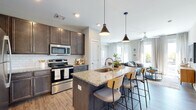 Located at 1620 W North Bend Rd in Cincinnati, Ohio, this single-floor residence offers a thoughtfully designed open-concept layout that seamlessly connects the kitchen, dining, and living areas. The kitchen is a standout feature, showcasing rich dark cabinetry, granite countertops, a subway tile backsplash, and a full suite of stainless steel appliances. A central island with seating provides both additional workspace and a casual dining option, while stylish pendant lighting adds a modern touch overhead. Wood-look flooring flows throughout the main living areas, enhancing the contemporary aesthetic.

The living room is bright and inviting, with large windows that usher in generous natural light and offer outdoor views. A ceiling fan and clean neutral walls complete the relaxed yet polished atmosphere.

The bedroom is spacious and carpeted, featuring large windows with outdoor views, a ceiling fan, and ample room for furnishings. Two bathrooms mirror the kitchen's refined style, each featuring granite-topped dark vanities and wood-look flooring. A convenient coat hook area near the entry adds practical functionality. Overall, the space presents a cohesive modern design with quality finishes throughout.