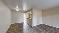 Located at 1649 W Thornhill Dr in Taylorsville, Utah, this single-floor, one-bedroom, one-bathroom unit offers a practical and functional layout across a compact footprint. The combined living and dining area greets you upon entry, finished with durable wood-look vinyl plank flooring and neutral beige walls that create a clean, versatile backdrop. A ceiling fan light fixture adds a practical touch to the living space. The kitchen is separated from the main living area by a half-wall pass-through with a breakfast bar, offering both visual connectivity and defined separation. The kitchen features wood-toned cabinetry, granite-style laminate countertops, and includes an electric coil range with overhead ventilation. The bedroom is comfortably sized, carpeted for warmth underfoot, and benefits from natural light through a window with blinds. A standout feature of the bedroom is the dual set of sliding-door closets, providing generous storage space. The bathroom includes a vanity with a granite-style countertop, an under-sink cabinet, a wall mirror, and a shower-tub combination. Throughout the unit, the neutral color palette and consistent finishes contribute to a cohesive, move-in-ready ambiance.
