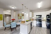 This well-designed 2-bedroom, 2-bathroom residence in Frederick, MD offers a thoughtfully laid-out single-level floor plan with modern finishes and comfortable living spaces throughout. The open-concept kitchen serves as the heart of the home, featuring white cabinetry, granite-style countertops, a center island with pendant lighting, and black appliances including a range, microwave, and refrigerator. The kitchen flows seamlessly into a combined dining and living area, where wood-look flooring, a ceiling fan, and a sliding glass door leading to a private balcony create a bright, airy atmosphere with outdoor views. Each bedroom is generously sized, highlighted by a spacious primary bedroom with plush carpeting, a ceiling fan, multiple windows for natural light, and a walk-in closet featuring built-in shelving and hanging rods. The two full bathrooms are finished with wide vanities, white cabinetry, and wood-look flooring. Additional highlights include a dedicated in-unit laundry closet with stacked washer and dryer hookups, two closets for ample storage, and a neutral color palette with tasteful accent walls that lend warmth and character throughout the home.