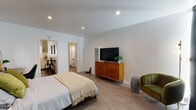 Located at 990 Palm Ave in the heart of West Hollywood, CA, this single-floor unit offers a thoughtfully designed layout that maximizes both function and comfort. The main living and sleeping area is open and generously proportioned, featuring smooth light wood-style flooring, recessed lighting, and clean white walls that create a bright, airy ambiance. A mid-century modern dresser and a cozy accent chair complement the space, while large dark curtains provide privacy and light control. The kitchen is efficiently laid out and well-equipped, featuring stainless steel appliances including a gas range, over-the-range microwave, and refrigerator, alongside white cabinetry with frosted glass upper doors and a window that invites natural light. The tile flooring and light countertops lend a clean, functional aesthetic. The bathroom is bright and neatly finished with tile flooring, a shower-tub combination, and a window for ventilation and natural light. A mirrored closet near the bathroom entry adds practical storage. The space flows seamlessly between its areas, making it an efficient and comfortable residence in one of Los Angeles' most vibrant neighborhoods.