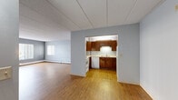 Located at 505 E Grant St in Minneapolis, MN, this 2-bedroom, 1-bathroom residence offers a practical and straightforward layout across a single floor. The open living room is a highlight of the space, featuring warm hardwood-style flooring, light gray walls, and multiple windows with vertical blinds that allow natural light to fill the room. A wall-mounted air conditioning unit and baseboard heating provide year-round climate control. The kitchen is neatly tucked into its own defined area, outfitted with rich wood cabinetry, light countertops, a coil-burner electric range, and a dishwasher — offering ample storage and functionality. A connecting hallway leads to the two bedrooms, both of which are carpeted and painted in soft, neutral tones. The primary bedroom is generously sized and features sliding wood-panel closet doors with built-in shelving, providing excellent storage. The second bedroom is comfortable with a window overlooking the exterior. The full bathroom includes a wood-vanity with under-sink storage, a large mirror, tile flooring, and a tub-shower combination. The overall design is clean and practical, making this a well-organized and livable space in the heart of Minneapolis.