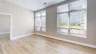 Located in the heart of downtown Columbus, Ohio, this well-appointed 2-bedroom, 2-bathroom residence offers a thoughtfully designed single-floor layout. The open-concept kitchen serves as the centerpiece of the living area, showcasing white cabinetry with gold-toned hardware, a geometric tile backsplash, sleek quartz countertops, stainless steel appliances, and a large island with pendant lighting — ideal for both cooking and entertaining. Light wood-style flooring flows throughout the main living areas, adding warmth and continuity to the space.

Both bedrooms are generously sized and feature plush neutral carpeting, soft grey walls, and large windows fitted with horizontal blinds that invite abundant natural light and offer views of the surrounding Columbus cityscape. Each bedroom is served by its own dedicated closet. The two bathrooms are finished with warm earth-tone tile flooring, white vanity cabinetry with gold accents, and coordinating countertops. One bathroom includes a full soaking tub with shower combination and accessibility grab bars, while the second offers a clean, streamlined design. The overall aesthetic throughout the residence is modern and neutral, creating a bright, cohesive, and move-in ready environment.