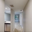 Located at 6701 Mallard Cove Rd, Building 28-C in Jupiter, Florida, this 610-square-foot, one-bedroom, one-bathroom apartment offers a clean and modern living environment across a single floor. Light wood-style flooring flows consistently throughout the unit, creating a cohesive and bright aesthetic.

The open kitchen and living area serves as the heart of the home. The kitchen features grey raised-panel cabinetry, quartz-style countertops with subtle veining, a white subway tile backsplash, and stainless steel appliances including a range and over-the-range microwave. The adjacent living area is well-lit with recessed lighting and ample wall space.

The primary bedroom spans 220 square feet and includes a ceiling fan with light fixture, a window with blinds allowing natural light, and a spacious walk-in closet with built-in shelving. The room features neutral grey walls and continues the light wood-style flooring found throughout the unit.

The bathroom is finished with large-format white tile in the tub/shower surround, wood-look tile flooring, and chrome fixtures, providing a clean and contemporary feel. Additional utility storage is accessible within the unit. The overall design palette of neutral greys, whites, and warm wood tones gives this apartment a fresh, move-in-ready appeal.