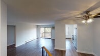 Located at 1934 Cambridge Ct in Palatine, IL, this single-floor unit offers a thoughtfully arranged layout with consistent hardwood-style flooring throughout. The main living area is open and spacious, anchored by large sliding glass doors that lead to a private balcony, allowing natural light to fill the room while providing pleasant outdoor views of surrounding greenery. A wall-mounted air conditioning unit and baseboard heating ensure year-round comfort. A ceiling fan with integrated lighting adds functionality to the adjoining area, which connects seamlessly to the rest of the unit.

The kitchen has been updated with light wood cabinetry, brushed nickel hardware, a subway tile backsplash, and clean white countertops. A deep single-basin stainless steel sink, pull-down faucet, and stainless steel dishwasher complete the space. The bedrooms are well-proportioned, each featuring hardwood-style flooring, baseboard heating, and windows that frame natural outdoor views. One bedroom includes a ceiling fan, a double closet with louvered doors, and ample wall space. The bathroom is cleanly finished with tile-surround tub, wood-style flooring, and a white vanity with storage.