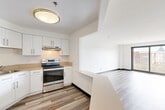 Located at 36 Dartmouth St in Malden, MA, this two-bedroom, three-bathroom residence offers a thoughtfully designed single-floor layout with a clean, modern aesthetic throughout. Light-toned wood-style flooring flows seamlessly across the living areas, complemented by crisp white walls and dark baseboards that provide a polished contrast.

The open-concept kitchen and living/dining area form the heart of the home. The kitchen features white shaker-style cabinetry, warm neutral countertops, stainless steel appliances including an electric range with overhead ventilation, and a breakfast bar that connects to the living and dining space. Large sliding glass doors in the living area lead to a private balcony, filling the room with natural light and providing outdoor access.

The spacious primary bedroom offers generous proportions and is served by its own dedicated closet space. The second bedroom is similarly well-sized with closet access. In total, five closets are distributed throughout the unit, providing exceptional storage. Three full bathrooms complete the layout, one of which features a full tub/shower combination with white tile flooring and a dual-sink vanity.

A hallway connects the private quarters to the main living areas, ensuring a functional and efficient floor plan. The overall design is clean and contemporary, making this a well-equipped residence in Malden.