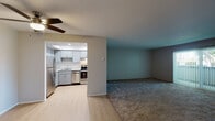 Located at 1120 W Olive Ave in Sunnyvale, California, this single-floor residence offers a practical and well-organized layout designed for comfortable everyday living. The open-concept living and kitchen area forms the heart of the home, where light wood-look flooring in the kitchen transitions seamlessly into carpeted living space. A ceiling fan overhead provides year-round comfort in the living area, which is bathed in a cool teal accent color that adds a modern touch to the neutral palette throughout.

The kitchen is thoughtfully equipped with grey shaker-style cabinetry, quartz countertops, stainless steel appliances including a refrigerator, range, and dishwasher, and a double-basin stainless steel sink. A skylight above the kitchen enhances natural illumination, creating a bright and functional workspace. Ample upper and lower cabinet storage ensures generous organization options.

The bedrooms are carpeted and generously sized, each featuring ceiling fans and vertical blinds over windows that allow for natural light and outdoor views. A closet with a hanging rod provides practical storage. The hallway connects the rooms efficiently and includes a vanity area with grey cabinetry and quartz countertops, consistent with the home's cohesive design aesthetic. Light wood-look flooring extends through the hallway, reinforcing the clean, modern feel of this Sunnyvale residence.