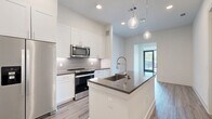 Located at 10400 Research Blvd in Austin, TX, this well-designed one-bedroom, one-bathroom residence offers a clean, modern aesthetic throughout its efficiently laid-out single floor. The open-concept kitchen serves as the heart of the home, showcasing a central island with a dark countertop and integrated sink, pendant lighting, crisp white shaker cabinetry extending to the ceiling, a mosaic tile backsplash, and a full suite of stainless steel appliances including a French door refrigerator, range, and microwave. Light wood-look flooring flows through the main living areas, lending warmth to the bright, neutral palette. Large floor-to-ceiling windows in the living area invite natural light and outdoor views of the surrounding greenery. The bedroom is carpeted for comfort, features a ceiling fan, and is served by a walk-in closet outfitted with built-in shelving and hanging rods on multiple walls. The bathroom is finished with large-format tile flooring, white cabinetry, a dark countertop vanity, and a glass-enclosed shower. Louvered closet doors near the entry provide additional storage. The overall ambiance is fresh, modern, and move-in ready.
