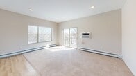 Located at 1330 High Site Drive in Eagan, Minnesota, this single-level residence offers a thoughtfully designed floor plan with two bedrooms, two bathrooms, dedicated closets, and an in-unit laundry area. The open-concept kitchen and living room serve as the heart of the home, finished with light hardwood-style flooring throughout. The kitchen is outfitted with rich dark cabinetwood cabinetry, stainless steel appliances including a refrigerator, range, and microwave, and a generous center island with a white countertop and undermount sink, illuminated by stylish pendant lighting. Large windows allow natural light to pour in, and a sliding glass door opens to a private balcony with views of the surrounding landscape. The spacious primary bedroom features vaulted ceilings, recessed lighting, and neutral carpet, creating a calm retreat. The second bedroom is similarly carpeted and well-proportioned with a window for natural light. Both bathrooms are cleanly finished with light hardwood-style flooring, tub-shower combinations, and white fixtures. One bathroom includes a dark wood vanity with ample storage. The neutral color palette and modern finishes throughout give the residence a clean, contemporary feel.