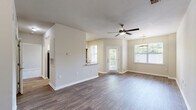 Located at 4625 Millbrook Green Dr in Raleigh, NC, this well-appointed one-bedroom, one-bathroom unit offers a thoughtfully designed single-level layout. The open-concept living and dining area is a welcoming focal point, featuring durable hardwood-style flooring, neutral-toned walls, and abundant natural light from multiple windows that frame views of surrounding greenery. A ceiling fan overhead adds comfort to the spacious living area, while a pendant light fixture elegantly defines the dining space. The kitchen is equipped with white shaker-style cabinetry, granite countertops, a stainless steel sink, and a full suite of stainless steel appliances including a refrigerator, range, and microwave. A pantry closet provides additional storage. The bedroom offers plush carpeting, a ceiling fan, a bright window with outdoor views, and direct access to a dedicated closet. The full bathroom includes a soaking tub with a tiled surround and shower combination. A private in-unit laundry room accommodates a full-size washer and dryer with overhead wire shelving for storage. Consistent hardwood-style flooring flows throughout the main living areas, creating a cohesive and clean aesthetic throughout the home.