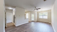 Located at 4625 Millbrook Green Dr in Raleigh, NC, this well-appointed one-bedroom, one-bathroom unit offers a thoughtfully designed single-level layout. The open-concept living and dining area is a welcoming focal point, featuring durable hardwood-style flooring, neutral-toned walls, and abundant natural light from multiple windows that frame views of surrounding greenery. A ceiling fan overhead adds comfort to the spacious living area, while a pendant light fixture elegantly defines the dining space. The kitchen is equipped with white shaker-style cabinetry, granite countertops, a stainless steel sink, and a full suite of stainless steel appliances including a refrigerator, range, and microwave. A pantry closet provides additional storage. The bedroom offers plush carpeting, a ceiling fan, a bright window with outdoor views, and direct access to a dedicated closet. The full bathroom includes a soaking tub with a tiled surround and shower combination. A private in-unit laundry room accommodates a full-size washer and dryer with overhead wire shelving for storage. Consistent hardwood-style flooring flows throughout the main living areas, creating a cohesive and clean aesthetic throughout the home.