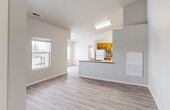 This single-story residence offers a practical and comfortable layout across two bedrooms and two bathrooms. The open-concept living and dining area is anchored by light wood-look flooring that flows throughout the entire unit, creating a cohesive and easy-to-maintain aesthetic. Large windows in the living area allow natural light to fill the space, offering views of the surrounding outdoor scenery.

The kitchen features warm honey-toned wood cabinetry, white appliances including a refrigerator, electric range, and built-in microwave, along with a peninsula counter that opens toward the living area. A notable convenience is the in-unit laundry closet located just off the kitchen, housing a full-size washer and dryer.

Both bedrooms are well-proportioned with neutral wall tones, wood-look flooring, and windows that bring in natural light. Each bedroom includes closet access and connects to the hallway corridor. The two bathrooms are clean and functional, each featuring a tub/shower combination, wood-toned vanity cabinetry, and matching flooring. A hallway connects all rooms efficiently, contributing to a logical and user-friendly floor plan. The overall design is clean, neutral, and move-in ready.