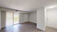 Located at 15 Fox Hall in Newark, Delaware, this single-floor, one-bedroom, one-bathroom residence offers a well-organized layout with a thoughtful mix of living spaces. The combined dining and living room is bright and open, featuring wood-style plank flooring, neutral gray walls, and a sliding glass door that leads to a private balcony with outdoor views, allowing natural light to fill the space. The kitchen is a standout feature, designed in a galley style with white shaker cabinetry, white quartz countertops, stainless steel appliances, and a bold cobalt blue subway tile backsplash that adds a striking visual accent. A convenient peninsula provides additional counter space and separates the kitchen from the living area. The bathroom echoes the kitchen's design aesthetic with the same vivid blue subway tile lining the tub surround, complemented by light gray floor tile and a clean white vanity. The bedroom offers comfortable carpeting, a closet, and a window with natural light. A dedicated den provides flexible additional space. The unit also includes a combined bathroom and laundry room with a stacked washer and dryer, three closets for ample storage, a hallway, and a utility room, rounding out a highly functional and well-appointed residence.