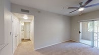 Located at 17374 N. 89th Ave. in Peoria, Arizona, this single-floor residence offers a well-designed layout with modern finishes throughout. The galley-style kitchen is a standout feature, showcasing white shaker cabinetry, granite-look countertops, a gray subway tile backsplash, dark hardwood-style flooring, and stainless steel appliances including a refrigerator, over-the-range microwave, and electric range. A double-basin stainless steel sink completes the functional workspace.

The living area is generously proportioned, featuring plush neutral carpeting, a ceiling fan with integrated lighting, and a sliding glass door that opens to an outdoor area, allowing natural light to fill the space. The bedroom continues the comfortable aesthetic with soft carpet, a ceiling fan, and easy access to additional rooms via classic six-panel doors.

The bathroom is finished with wood-look flooring, white cabinetry with brushed nickel hardware, granite-style countertops, a framed mirror, a multi-bulb vanity light fixture, and a full tub-shower combination with white tile surround. The neutral color palette of soft gray walls and white trim is carried consistently throughout, creating a cohesive and clean ambiance well-suited for comfortable everyday living.