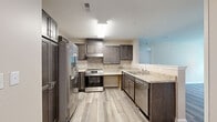 Located at 2140 Old Hundred Road in Midlothian, Virginia, this single-floor, 3-bedroom, 2-bathroom home offers a well-designed layout with contemporary finishes throughout. The kitchen is a standout feature, showcasing rich dark-toned cabinetry, light granite-style countertops, a stone tile backsplash, and a full suite of stainless steel appliances including a refrigerator with ice maker, electric range, and dishwasher. Light wood-look flooring runs throughout the kitchen and living areas, lending a clean, modern aesthetic. Each of the three bedrooms provides a comfortable, neutral environment with warm beige walls, wood-look flooring, and windows that invite natural light and outdoor views. The primary bedroom includes access to a dedicated closet with wire shelving, offering generous storage. A total of eight closets are distributed throughout the home, ensuring abundant storage options. Both bathrooms are finished with multi-toned slate-style tile flooring and dark wood vanities with white countertops. One bathroom features a full tub-shower combination, while the other offers a more open layout. The hallway connects all rooms efficiently, contributing to a functional and cohesive floor plan suited for comfortable everyday living.
