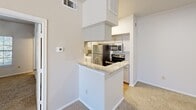Located at 165 Forestbrook Dr in Lewisville, TX, this single-floor, one-bedroom, one-bathroom unit offers a practical and comfortable layout. The galley-style kitchen is a standout feature, lined with gray cabinetry, granite countertops, hardwood-style flooring, and a full suite of stainless steel appliances including a refrigerator, electric range, microwave, and dishwasher. A peninsula counter extends into the living area, providing additional prep space and a natural transition between the kitchen and the carpeted living room. The living area is open and airy, benefiting from vaulted ceilings that add a sense of spaciousness. The bedroom offers a comfortable footprint with soft carpet flooring, vaulted ceilings, and a mirrored sliding closet door that enhances the sense of space and light. The bathroom is cleanly finished with hardwood-style flooring, a granite-topped vanity with gray cabinetry, a wall-mounted mirror, and a full tub/shower combo with white tile surround. In-unit laundry hookups are also visible, adding everyday convenience. Throughout the unit, neutral tones and clean finishes create a cohesive and move-in-ready atmosphere.