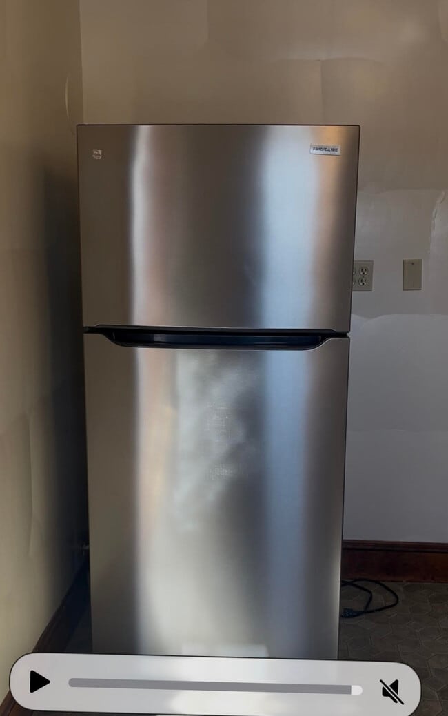 New stainless steel refrigerator with space for a microwave car to the right - 52 Old Fort Rd
