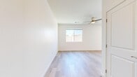 Located at 7641–7685 Calloway Dr in Bakersfield, CA, this thoughtfully designed single-floor unit offers a clean, modern aesthetic with a bright and airy atmosphere. The open-concept living and kitchen area serves as the heart of the space, where light wood-tone flooring flows seamlessly underfoot. The kitchen is well-appointed with shaker-style cabinetry in a soft gray finish, white quartz countertops, a classic white subway tile backsplash, and a full suite of stainless steel appliances including a refrigerator, range, over-the-range microwave, and dishwasher. A peninsula provides additional prep and dining space, while a sliding glass door connects the living area to the outdoors, filling the room with natural light. Recessed lighting adds a polished touch overhead. The bedrooms are comfortably sized, featuring a mix of light wood flooring and plush carpet, ceiling fans for climate comfort, and windows that offer views of the surrounding neighborhood. The bathroom is clean and functional, finished with white tile surrounding a soaking tub and chrome fixtures. Crisp white walls and consistent design details throughout give the entire space a fresh, move-in-ready feel.