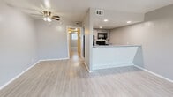 Located at 411 Ponder Ave in Denton, TX, this single-story 1-bedroom, 1-bathroom home offers a clean, functional layout with a cohesive neutral palette throughout. Light wood-style flooring runs continuously across all rooms, creating a bright and unified aesthetic.

The combined kitchen and living area forms the heart of the home. The living room features a ceiling fan and a front-facing entry door flanked by a window, allowing natural light to fill the space. The galley-style kitchen is well-equipped with gray cabinetry, a gas range, stainless dishwasher, full-size refrigerator, and a double-basin sink — all finished with recessed lighting overhead.

A hallway connects the main living area to the private quarters. The bedroom is generously proportioned, featuring gray walls, a ceiling fan, and a window with blinds that provides natural light. It is complemented by a dedicated walk-in closet outfitted with dual hanging rods and shelving on both sides, offering ample storage.

The bathroom features a full tub-shower combination with white tile surround, maintaining the home's clean and minimal aesthetic. The consistent use of light gray tones, white trim, and wood-style flooring throughout gives the entire space a modern, move-in-ready feel.