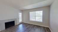 This single-story 1-bedroom, 1-bathroom unit offers a functional and well-designed layout. The combined kitchen and living area serves as the heart of the home, featuring durable wood-style flooring that extends throughout the main living spaces. The living room is bright and airy, highlighted by large windows with blinds that invite generous natural light, a sliding door entry, and a tile-surround fireplace that adds a welcoming focal point to the space.

The kitchen is thoughtfully designed with white cabinetry, a peninsula with countertop seating, white appliances including a range and refrigerator, and a dedicated dining area accented by a chandelier overhead. The kitchen flows seamlessly into the living space, creating an open and connected feel.

The bedroom is comfortably sized, featuring plush carpeting, a ceiling fan with light fixture, a window for natural light, and access to two closets — including a spacious walk-in closet outfitted with wire shelving and additional storage racks for maximum organization.

The bathroom is clean and functional, featuring a soaking tub with a tiled shower surround and chrome fixtures. A hallway connects the main living areas to the private bedroom and bath, completing this efficient and comfortable single-floor layout.