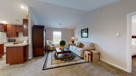 Located in Sheffield, Ohio, this well-maintained home offers a thoughtfully designed layout across a single floor, complemented by upper-level living space accessible via carpeted stairs with warm wood railings. The kitchen is a functional centerpiece, featuring rich cherry cabinetry, a granite-topped island with bar seating, recessed lighting, and light hardwood-style flooring — all oriented toward a sun-filled dining area. The dining room is a highlight, with an arched transom window, a sliding glass door opening to a deck, and a classic chandelier overhead, offering pleasant views of the surrounding neighborhood greenery. The vaulted living room provides an airy, relaxed atmosphere, with plush carpeting, ample natural light from a double-hung window, and generous space for comfortable seating arrangements. Additional rooms include a carpeted sitting room ideal for a study or flex space, and a spacious walk-in closet with wire shelving. A full bathroom features wood-toned cabinetry, hardwood-style flooring, and a shower-tub combination. The dedicated laundry room houses a full washer and dryer set, utility sink, overhead shelving, and mechanicals — ensuring practical day-to-day convenience throughout this inviting home.