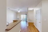 Located at 511 Washington St in Hanover, MA, this well-designed two-bedroom, two-bathroom residence offers a functional and comfortable single-floor layout. The open living and dining area is finished with warm hardwood-style flooring and features a ceiling fan, creating an airy atmosphere. Sliding glass doors lead to a private balcony, allowing natural light to fill the main living space. The kitchen is efficiently laid out with tile flooring, granite-look countertops, cream cabinetry, and stainless steel appliances including an electric range, built-in microwave, and refrigerator. A dedicated dining area connects seamlessly to the kitchen and living room. Both bedrooms are carpeted and offer a calm, neutral palette with ample closet space via sliding double-door closets. The spacious primary bedroom includes its own adjoining bathroom. The second full bathroom features tile flooring, a white vanity with sink, a large mirror, and a tub-shower combination. Three closets throughout the unit provide generous storage. In-unit laundry adds everyday convenience, and a hallway ties all rooms together in a practical, well-organized floor plan.