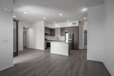 Located at 9174 Indiana Ave in Riverside, California, this modern single-floor residence showcases a thoughtfully designed open layout with clean finishes throughout. The kitchen serves as a central hub of the space, featuring warm wood-tone cabinetry, a classic white subway tile backsplash, gleaming quartz countertops, a center island with additional storage, and a full suite of stainless steel appliances including a gas range, microwave, dishwasher, and refrigerator. Light wood-style flooring flows seamlessly from the kitchen through the open living area, which is filled with natural light and offers direct access to an outdoor balcony. The bedrooms provide a comfortable contrast with soft carpeted flooring, large windows fitted with blinds for natural light and privacy, and ceiling fans for added comfort. One bedroom opens directly to the outdoor space, enhancing its airy feel. The bathrooms are finished with matching wood-tone vanities, white quartz countertops, large mirrors, and light wood-style flooring. One bathroom includes a full tub-shower combination, while the other features a streamlined vanity layout. The overall ambiance is fresh, bright, and move-in ready, reflecting a clean contemporary aesthetic suited for comfortable modern living.