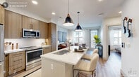 Located at 1250 Hitchings Way in Durham, NC, this thoughtfully designed one-bedroom, one-bathroom residence offers a modern open-concept layout that maximizes its efficient footprint. Light wood-tone flooring flows throughout, connecting each space seamlessly.

The kitchen serves as the heart of the home, anchored by a white quartz waterfall island with seating, stainless steel appliances, warm wood cabinetry, a subway tile backsplash, and stylish pendant lighting overhead. The kitchen opens directly into the living area, which is bathed in natural light from large windows and a glass door leading to a private balcony with views of the surrounding community.

The bedroom is a serene retreat featuring a bold teal accent wall, a ceiling fan, and a bright window that fills the room with natural light. A dedicated closet provides convenient storage.

The bathroom is clean and well-appointed, with a wood-tone vanity, white tile flooring, and a full tub-shower combination framed by classic white subway tile.

Throughout the residence, a neutral, contemporary palette with modern fixtures and recessed lighting creates a cohesive and inviting ambiance — ideal for comfortable urban living in Durham.