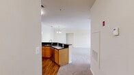 Located in the Broadlands community of Ashburn, VA, this well-appointed 2-bedroom, 2-bathroom home offers a thoughtfully designed single-floor layout. The living room serves as the centerpiece of the home, featuring elegant crown molding, plush carpeting, a classic fireplace, and large windows with transom panels that flood the space with natural light and offer views of the surrounding neighborhood. The kitchen is outfitted with warm honey-toned wood cabinetry, dark granite countertops, hardwood flooring, and a full suite of stainless steel appliances including a gas range, microwave, and refrigerator. The generously sized primary bedroom includes a ceiling fan, a bank of large windows, and access to a spacious walk-in closet with wire shelving. The second bedroom also features a ceiling fan and ample natural light. Both bathrooms are finished with warm wood vanities, white countertops, and tiled tub-shower combinations. A dedicated laundry area houses a full-size side-by-side washer and dryer with overhead shelving for added convenience. Throughout the home, carpeted bedrooms and living areas lend a comfortable, cohesive feel, while crown molding in the main living spaces adds a refined touch.