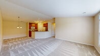 Located at 6832 Wales Crossing St NW in North Canton, Ohio, this single-floor residence offers a well-organized layout across two bedrooms and two full bathrooms. The living room is generously sized, featuring plush carpeting, warm neutral walls, and large windows that invite abundant natural light and outdoor views. An entrance with hardwood-style flooring leads seamlessly into the main living areas.

The open-concept kitchen connects directly to the living and dining spaces, featuring warm honey-toned wood cabinetry, dark granite-style countertops, a curved breakfast bar peninsula, recessed lighting, and a ceiling fan. White appliances, including a range, microwave, and refrigerator, complement the hardwood-style kitchen floor.

The dining area is accented by vaulted ceilings and an elegant chandelier, adding height and character to the space. The spacious primary bedroom includes vaulted ceilings, a ceiling fan, a window with outdoor views, and access to a dedicated closet. The bathrooms feature tile flooring, white vanities, large mirrors, and a glass-enclosed shower. A dedicated laundry room houses a full-size washer and dryer, completing this functional and comfortable home.