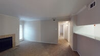 This single-floor, two-bedroom, two-bathroom residence in Houston, TX offers a well-organized layout designed for comfortable everyday living. The living room serves as the heart of the home, featuring a tile-surround fireplace, crown molding, and a window that brings in natural light. A pass-through opening connects the living area to the galley-style kitchen, which is equipped with white cabinetry, a coil-top electric range, a full-size refrigerator, and speckled countertops — all set atop wood-look flooring for easy maintenance. An adjacent hallway leads into the rest of the unit, providing a clear and functional flow throughout.

Both bedrooms are carpeted and generously proportioned, each equipped with a ceiling fan and light fixture. Closet access is available in the bedrooms, offering practical storage solutions. The two bathrooms are clean and simply appointed — one features a full tub/shower combo with white tile surround and wood-look flooring, while the other includes a wide vanity with a speckled countertop, an undermount sink, and a large mirror with overhead lighting. Crown molding details in the main living areas add a touch of architectural character to this straightforward and functional Houston residence.