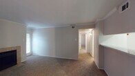 This single-floor, two-bedroom, two-bathroom residence in Houston, TX offers a well-organized layout designed for comfortable everyday living. The living room serves as the heart of the home, featuring a tile-surround fireplace, crown molding, and a window that brings in natural light. A pass-through opening connects the living area to the galley-style kitchen, which is equipped with white cabinetry, a coil-top electric range, a full-size refrigerator, and speckled countertops — all set atop wood-look flooring for easy maintenance. An adjacent hallway leads into the rest of the unit, providing a clear and functional flow throughout.

Both bedrooms are carpeted and generously proportioned, each equipped with a ceiling fan and light fixture. Closet access is available in the bedrooms, offering practical storage solutions. The two bathrooms are clean and simply appointed — one features a full tub/shower combo with white tile surround and wood-look flooring, while the other includes a wide vanity with a speckled countertop, an undermount sink, and a large mirror with overhead lighting. Crown molding details in the main living areas add a touch of architectural character to this straightforward and functional Houston residence.