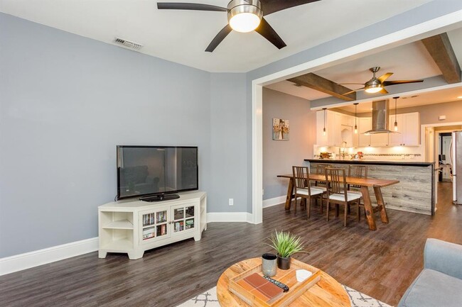 As you enter, enjoy an open living area. Notice the wood beams in the open dining area. - 732 E 12th 1/2 St