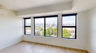 Located at 514 SE Belmont St. in Portland's vibrant SE neighborhood, this modern studio offers a thoughtfully designed single-floor layout comprising a living room, kitchen, bathroom, and closet. The living area is a standout space, framed by a wall of large, black-trimmed windows that flood the room with natural light and frame sweeping views of the Portland skyline and lush tree canopy below. Light-toned hardwood flooring runs throughout, complementing the clean, contemporary aesthetic. A wall-mounted mini-split system provides efficient heating and cooling comfort. The kitchen is well-appointed with dark espresso cabinetry reaching to the ceiling, white quartz countertops, a classic subway tile backsplash, and a full suite of stainless steel appliances including a gas range, over-the-range microwave, refrigerator, and dishwasher. The deep single-basin sink adds to the kitchen's functional appeal. The bathroom features a soaking tub/shower combination finished with crisp white stacked tile surround and polished chrome fixtures. A dedicated closet provides convenient built-in storage. The overall ambiance is clean, bright, and contemporary, making efficient use of its compact footprint in one of Portland's most walkable and sought-after urban corridors.