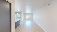 Located at 2900 E Anamosa St in Rapid City, South Dakota, this well-designed one-bedroom, one-bathroom residence offers a thoughtfully organized single-floor layout with modern finishes throughout. The combined kitchen and living area serves as the heart of the home, featuring light wood-look flooring, recessed and pendant lighting, and a central island with a double sink and crisp white countertops. Dark, richly toned cabinetry adds contrast, while black stainless appliances—including a refrigerator, range, and over-the-range microwave—complete the functional kitchen. A sliding glass door provides access to an outdoor area, filling the space with natural light. The bedroom offers comfortable carpeting, a window with natural light and neighborhood views, and direct access to a generously sized walk-in closet equipped with multi-level wire shelving for ample storage. The bathroom is finished with tile flooring and includes a full tub-shower combination with a curved curtain rod. A dedicated laundry room houses a full-size washer and dryer with overhead wire shelving, adding everyday convenience. Neutral wall tones and clean lines throughout create a bright, cohesive atmosphere well-suited for comfortable living.