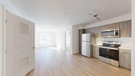 Located in Bellevue, WA, this 2-bedroom, 1-bathroom unit offers a thoughtfully designed single-floor layout that maximizes its well-utilized footprint. The open-concept living and kitchen area is anchored by light hardwood-style flooring and crisp white walls, creating a clean and airy atmosphere. Natural light pours in through large windows, enhancing the bright, welcoming ambiance throughout.

The kitchen is well-appointed with warm wood-toned cabinetry, white quartz countertops, and a full suite of stainless steel appliances including a refrigerator, electric range, microwave, and dishwasher. A track lighting fixture overhead adds both style and practicality.

Both bedrooms feature plush wall-to-wall carpeting, ceiling fans with light fixtures, and windows that invite natural light and views of the surrounding neighborhood. The primary bedroom is generously sized and provides access to a shared bathroom and closet space. A second closet offers additional storage convenience.

The bathroom is finished with a wood-toned vanity, white quartz countertop, and a large mirror, maintaining the cohesive modern aesthetic found throughout the unit. Two closets provide ample storage. The overall design is modern, clean, and functional, making this unit a comfortable and practical home in the heart of Bellevue.