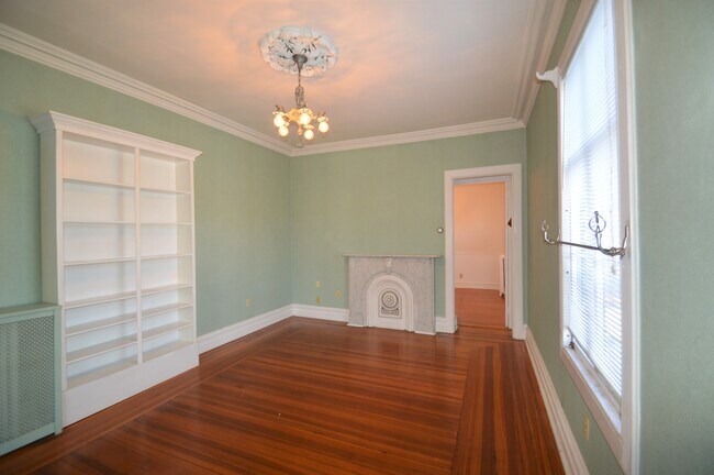 A stately chandelier and decorative fireplace add character to the living area - 226 Broadway