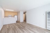 Located at 801 14th St in Oakland, CA, this one-bedroom, one-bathroom unit offers a thoughtfully laid-out single-floor plan with a clean, neutral aesthetic throughout. Light wood-style flooring runs continuously across all rooms, creating a cohesive and easy-to-maintain living environment.

The combined kitchen and living area forms the heart of the unit. The kitchen features light wood cabinetry with silver hardware, light-toned countertops, a double sink, and white appliances including a refrigerator, electric range with overhead exhaust, and dishwasher. The adjacent living room is open and bright, benefiting from a large sliding window that allows ample natural light to fill the space. A wall-mounted heater unit provides climate control.

The bedroom offers comfortable proportions with a window providing additional natural light and direct access to a dedicated closet area. A separate hallway closet features built-in white shelving, ideal for additional storage needs.

The bathroom is finished with light wood cabinetry, a light countertop vanity, a tiled shower-tub combination, and chrome fixtures. Neutral wall tones and consistent flooring tie the bathroom seamlessly into the rest of the unit's design. The hallway connects all areas efficiently, completing this well-organized and functional living space.