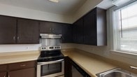 Located at 4950 Government Blvd in Mobile, Alabama, this two-story residence offers a practical and comfortable layout across two well-organized floors. The kitchen is appointed with dark espresso cabinetry providing ample upper and lower storage, light-toned countertops, a stainless steel electric range with an overhead ventilation hood, and tile flooring — creating a functional cooking space. The main living area features rich hardwood flooring, a ceiling fan with light fixture, and a window that brings in natural light. Multiple bedrooms are finished with plush carpeting, ceiling fans, and windows fitted with blinds. One bedroom benefits from direct access to a en-suite bathroom, which includes a double-sink vanity with warm wood cabinetry, a wide mirror with overhead lighting, and tile flooring. Additional bedrooms offer louvered closet doors and generous natural light. The bathrooms throughout the home are finished with tile flooring and include tub-shower combinations with white tile surrounds. A secondary full bathroom features a single-sink vanity with wood cabinetry. The textured ceilings and consistent neutral color palette throughout contribute to a clean, cohesive aesthetic across both levels of the home.