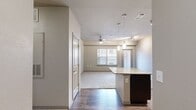 This thoughtfully designed 2-bedroom, 2-bathroom residence offers a functional and comfortable single-floor layout. The open-concept living and kitchen area serves as the heart of the home, where wood-style flooring transitions seamlessly from the kitchen into the carpeted living space. The kitchen is highlighted by rich dark-cabinetry, a granite-topped island with pendant lighting above, track lighting, and black appliances, providing both style and practicality. The living area features a ceiling fan and a window that brings in natural light.

Both bedrooms are carpeted and generously sized, each equipped with a ceiling fan and a window. The spacious primary bedroom connects to its own en-suite bathroom, complete with dark wood vanity cabinetry, a large mirror, wood-look tile flooring, and a walk-in closet with built-in shelving. The second bathroom mirrors this refined aesthetic with matching finishes. A dedicated in-unit laundry room with overhead shelving adds everyday convenience. With five closets throughout, storage is plentiful. The neutral color palette and consistent finishes create a cohesive, clean ambiance across the entire residence.