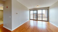 Located at 1646 River St in Des Plaines, Illinois, this single-floor residence offers a well-appointed layout with consistent warm hardwood flooring throughout its living spaces. The open-concept kitchen is a standout feature, showcasing rich cherry-toned cabinetry, dark granite countertops with natural stone patterning, and a full suite of stainless steel appliances including a refrigerator, range, and built-in microwave. A peninsula with matching granite provides additional prep and seating space, seamlessly connecting the kitchen to the main living area.

The living room is bright and generously proportioned, highlighted by large sliding glass doors that open to a private balcony offering open views of the surrounding Des Plaines cityscape. Bedrooms continue the hardwood flooring aesthetic and are well-sized, with one featuring a walk-in closet and direct access to additional rooms. Windows in the bedrooms allow ample natural light and urban views to filter in.

The bathroom is finished with neutral tile flooring and includes both a soaking tub and a separate glass-enclosed shower stall, providing a functional and clean spa-like setting. A utility area with an electrical panel is also accessible within the unit. The overall design is clean and modern, with neutral wall tones creating a versatile and move-in-ready environment.