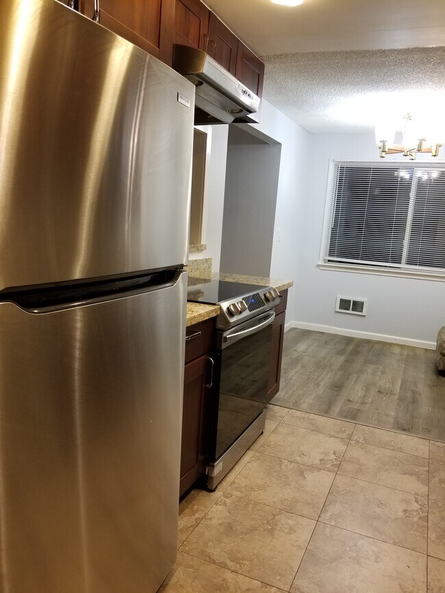 Kitchen with service/bar counter, dining area and new appliances! - 17204 NE 45th St