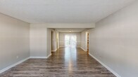 Located at 276 Upper Riverdale Rd in Jonesboro, GA, this single-floor, 3-bedroom, 1-bathroom home offers a practical and comfortable layout. The open living area is a standout feature, showcasing rich, dark wood-style flooring that extends throughout the main living spaces. Natural light pours in through a large sliding glass door at the far end of the room, creating a bright and welcoming atmosphere. Textured ceilings add a classic touch throughout the home.

The kitchen is efficiently designed with white cabinetry, a gas range, a full-size refrigerator, a stainless steel sink, and wood-style flooring, providing a clean and functional cooking space.

The three bedrooms are carpeted for comfort and each features a window that brings in natural light and outdoor views of surrounding greenery. The primary bedroom is notably spacious, complete with a ceiling fan and a closet with built-in shelving. The additional bedrooms also include ceiling fans, enhancing year-round comfort.

The bathroom is well-appointed with a double-sink vanity, a large mirror, and wood-style flooring, offering ample counter space. Two closets provide additional storage throughout the home. The layout is completed by a connecting hallway that ties all rooms together efficiently.
