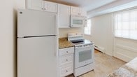 Located at 82 Shore Dr in Peabody, Massachusetts, this two-floor home offers a thoughtfully arranged layout with distinct living spaces across both levels. The main floor greets visitors with generously sized living areas finished in warm parquet wood flooring, arranged in a classic basket-weave pattern that adds visual character throughout. A carpeted staircase with a traditional wooden banister and turned newel post connects the two floors, serving as a functional centerpiece of the home's interior.

The kitchen is equipped with white cabinetry, granite-style countertops, and white appliances including a refrigerator, electric range, and over-the-range microwave. Tile flooring and a window provide a bright, practical workspace. A half bathroom on the lower level features a window with natural light, a vanity, and a mirrored medicine cabinet.

The upper floor features multiple rooms with polished hardwood flooring that reflect natural light from well-placed windows. Bedrooms are bright and comfortably sized, each benefiting from baseboard heating and natural light. A full bathroom on this level includes a tub-shower combination, toilet, vanity, and mirrored medicine cabinet. Throughout both floors, the neutral color palette and clean finishes contribute to a bright, move-in-ready atmosphere.