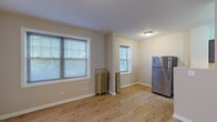 Located at 1116 Washington Blvd in the well-regarded community of Oak Park, Illinois, this single-floor unit offers a thoughtfully updated interior with a clean, neutral aesthetic throughout. Light-toned hardwood flooring runs consistently across all living areas, lending warmth and visual continuity to the space.

The kitchen is well-appointed with rich dark cabinetry, granite countertops, and stainless steel appliances including a full-size refrigerator and gas range. Ample counter and storage space make it highly functional for everyday use.

The living and dining areas are generously proportioned, with multiple windows fitted with horizontal blinds that allow for natural light while maintaining privacy. Classic cast-iron radiators are present in several rooms, adding a charming architectural detail characteristic of the building's era.

The bedroom is comfortably sized, featuring a ceiling fan, a bright window, and a closet. The full bathroom is finished with large-format tile in the tub surround accented by a mosaic tile border, complemented by a dark-stained vanity with a marble-top countertop and framed mirror.

An additional open area with a stainless steel refrigerator and electrical panel provides flexible utility space. The overall ambiance is clean, updated, and move-in ready, situated in one of the Chicago area's most architecturally distinctive neighborhoods.