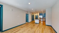 This thoughtfully designed 1-bedroom, 1-bathroom residence in Titusville, Florida offers a cohesive blend of modern style and functional living. The open-concept kitchen and living area serves as the heart of the home, showcasing striking teal cabinetry, light wood lower cabinets, and a bold patterned tile backsplash. A large island with a dark granite countertop and a farmhouse-style sink anchors the space, complemented by stainless steel appliances and pendant lighting overhead. Light wood-style flooring flows throughout the main living areas, enhancing the bright and airy atmosphere created by multiple windows with blinds. The living room provides ample space and direct access to a private balcony overlooking a resort-style pool and landscaped courtyard. The bedroom offers comfortable carpeted flooring, a ceiling fan, and natural light from dual windows. A dedicated closet provides practical storage. The bathroom features a tiled tub-shower combination, wood-toned vanity with granite countertops, and light flooring that ties the space together. Teal accent doors and trim throughout add a cohesive, contemporary design touch that distinguishes this well-finished residence.
