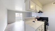 Located at 13450 Esperanza Road in Dallas, TX, this thoughtfully laid-out unit makes efficient use of its single-floor footprint. The open-plan kitchen and living area serves as the heart of the space, featuring light wood-style flooring, a neutral gray and white color palette, and abundant natural light. The kitchen is well-appointed with marble-look countertops, white cabinetry, a black range and refrigerator, and a peninsula counter that doubles as a breakfast bar — seamlessly connecting cooking and living areas. A sliding glass door in the living area opens directly onto a private balcony, offering outdoor views of the surrounding neighborhood. The bathroom is clean and functional, featuring a tiled tub/shower combo, wood-style flooring, and a marble-look vanity countertop consistent with the unit's overall aesthetic. Additional spaces include a dedicated closet for storage, a pantry for kitchen overflow, and a hallway that connects the rooms efficiently. Throughout the unit, consistent light flooring, crisp white trim, and soft neutral wall tones create a cohesive, modern ambiance that feels clean and inviting. The layout maximizes every square foot, making this a practical and comfortable space.