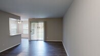 Located at 5341 Columbia Rd in Columbia, Maryland, this one-bedroom, one-bathroom residence offers a well-designed, efficiently laid-out single-floor living space. The combined kitchen and living room serves as the heart of the home, featuring dark hardwood-style flooring, neutral gray walls, and a sliding glass door with vertical blinds that fills the area with natural light and provides direct outdoor access. A side window further brightens the space.

The kitchen is outfitted with white shaker-style cabinetry, light countertops, and a full suite of stainless steel appliances, including a refrigerator, electric range, and over-the-range microwave, all set against a classic tile backsplash.

The bedroom is carpeted for comfort and receives natural light through a window with blinds. It connects directly to a dedicated walk-in closet with built-in shelving, as well as providing easy access to the full bathroom. The bathroom features a white vanity with an integrated sink, a tiled shower-tub combination, and clean, neutral finishes throughout.

A separate in-unit laundry room houses a full-size washer and dryer with wire shelving above for added storage. The entrance provides a smooth transition into the main living areas, completing this thoughtfully organized and move-in-ready residence.