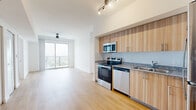 Located in Houston, TX, this thoughtfully designed 3-bedroom, 2-bathroom residence offers a clean, contemporary aesthetic across a single floor. The open-concept kitchen and living area serves as the heart of the home, featuring light wood-grain cabinetry, granite countertops, a tile backsplash, and a full suite of stainless steel appliances including a range, microwave, dishwasher, and refrigerator. Track lighting overhead and light wood-tone flooring throughout create a bright, cohesive feel. The living area extends toward floor-to-ceiling sliding glass doors that open onto a private balcony, offering elevated outdoor views of the surrounding Houston landscape. Each of the three bedrooms is finished with the same warm wood flooring, crisp white walls, and ceiling fans, with windows fitted with horizontal blinds for light control. The primary bedroom includes access to a dedicated closet with wire shelving for organized storage. The bathrooms are well-appointed, featuring granite-topped vanities with wood cabinetry, full tub-shower combinations with subway-style tile surrounds, and recessed lighting. The consistent use of natural tones and modern finishes throughout gives the entire residence a clean, welcoming ambiance.