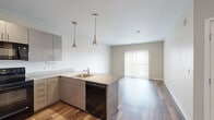 Located at 8861 Eaton St in Westminster, CO, this well-appointed two-bedroom, three-bathroom residence offers a thoughtfully designed single-level layout. The open-concept kitchen and living area serves as the heart of the home, featuring sleek gray cabinetry, granite countertops, and a peninsula with a stainless steel sink and built-in dishwasher. Stylish pendant lights hang above the peninsula, while black appliances—including a refrigerator, range, and microwave—complete the modern kitchen. Wood-style flooring flows throughout the main living areas, adding warmth and continuity. The living room is bright and open, anchored by a sliding glass door with vertical blinds that fills the space with natural light and provides outdoor access. Both bedrooms are carpeted for comfort, each featuring windows with exterior views and generous closet space, including a walk-in closet with wire shelving. Three bathrooms are finished consistently with granite-top vanities, gray cabinetry, and wood-style flooring. The neutral color palette throughout creates a clean, contemporary ambiance. The overall layout is efficient and functional, offering comfortable living across a well-utilized footprint in a convenient Westminster location.